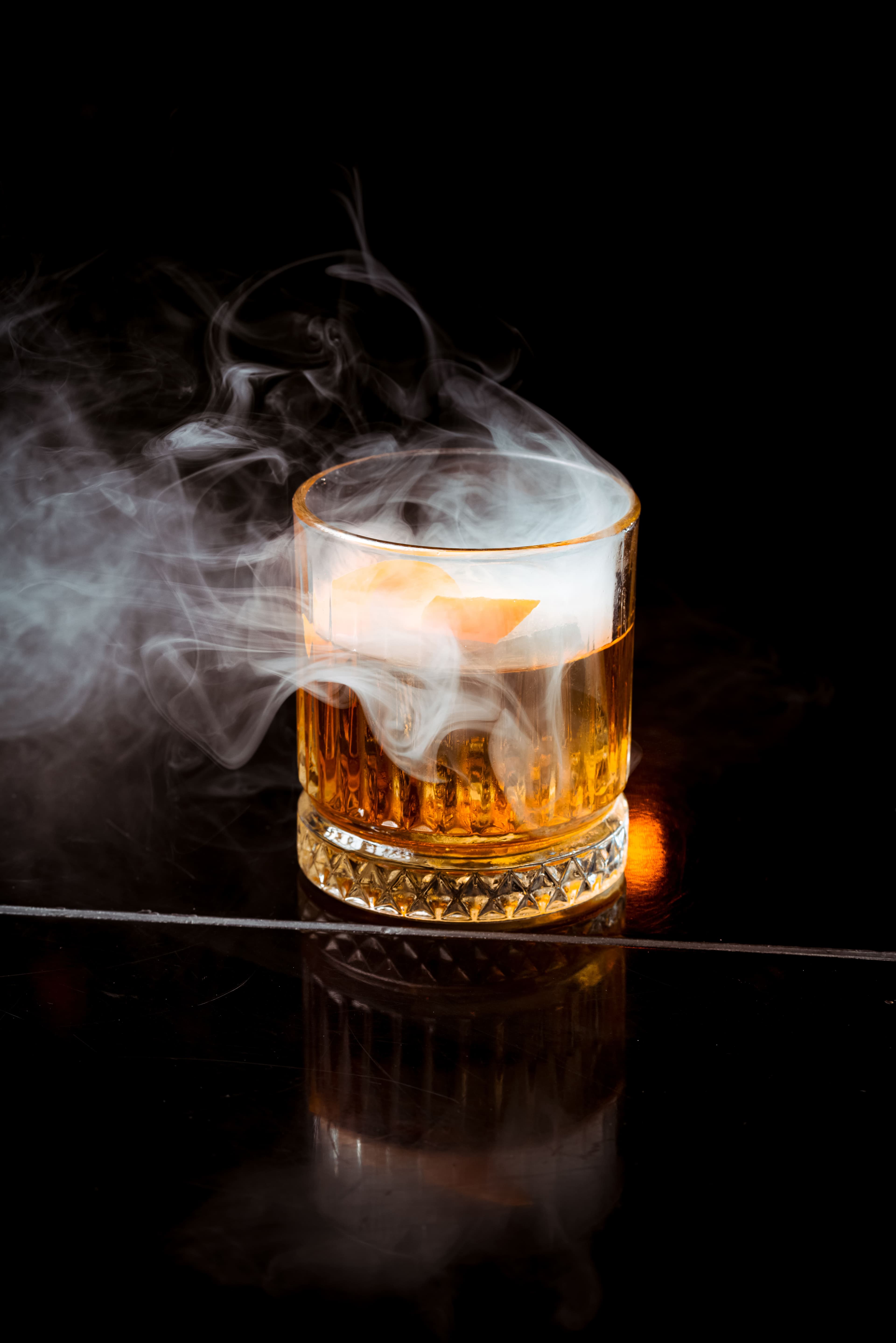 Smoky signature drink with dramatic light